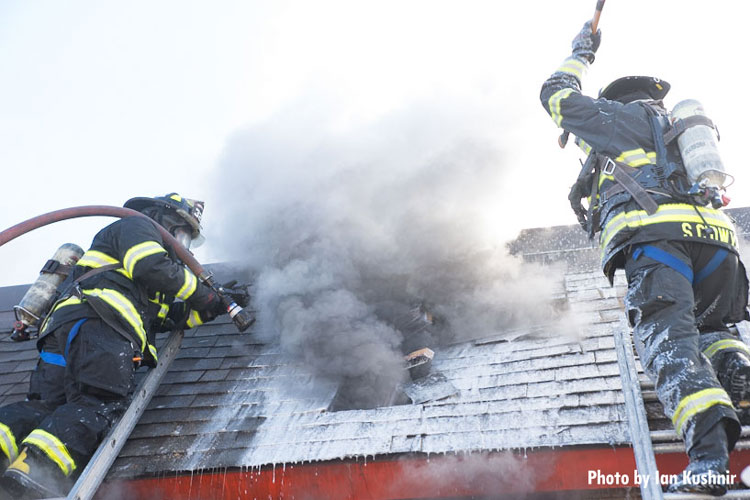 Firefighters with a line at they opened up the roof