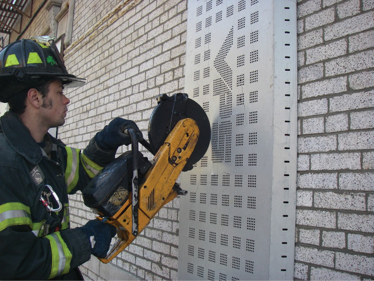 (12) This firefighter is cutting the VPS bars inside the window guard. 