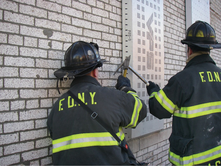 (13) Firefighters are using forcible entry tools to pry the window covering off. 