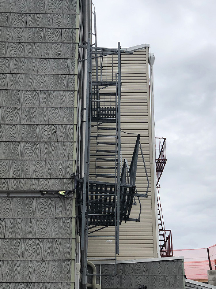 A look from the side of this wood-frame multiple dwelling fire escape indicates structural distress in the second-floor platform. (Photos by author.) 