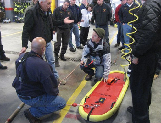 Surface ice rescuers from the Bayport (NY) Fire Department and other departments sketch and write out the procedures for the TeamLGS surface ice rescue leapfrogging rigging system after learning how to set it up and use it during land exercises. (Photos 1-5 by Barry Lipsky.)