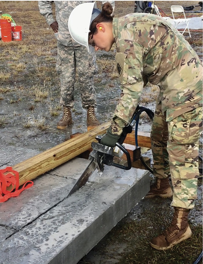 The soldier is making the final two cuts with a concrete chain saw that can cut the full thickness of the slab.