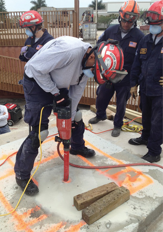  Task force members use a core drill to create an inspection hole. 