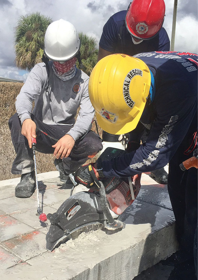 After the concrete is marked to form nine rectangles, firefighter students at the Coral Springs (FL) Regional Institute of Public Safety use the saw to cut relief cuts along the grid. 