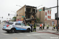 A Chicago police car and Chicago firefighters on scene.