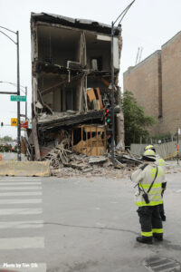 A Chicago fire official with the damaged building in the background.