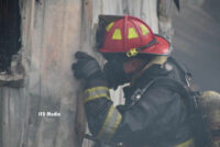 A firefighter peers into the structure