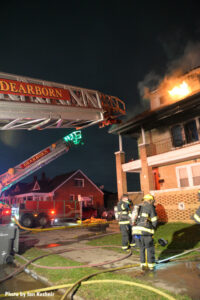 Firefighters and two aerial devices set up outside the home.