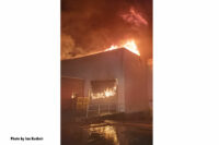 Flames shoot through the building's roof