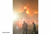 Firefighters working as flames erupt from the building