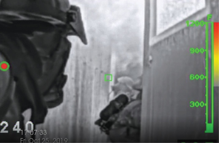 A still photo from the thermal imaging camera (TIC) of firefighters in the hallway after knockdown.