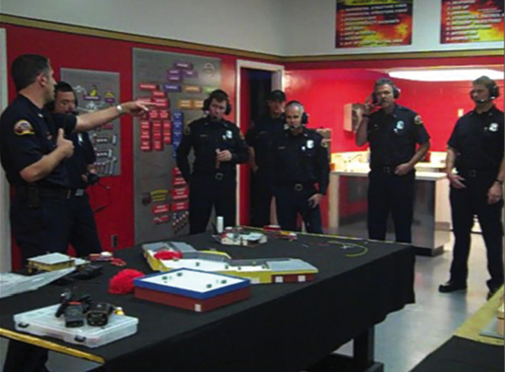 Company officers training on a tabletop model with radios.