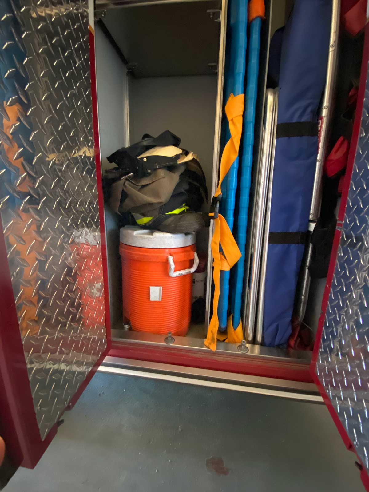 More firefighter gear inside a fire truck compartment