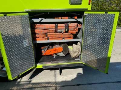 Hose bundles and saws stowed in a fire apparatus compartment