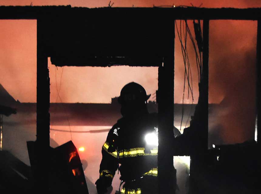 A firefighter amid the ruins of a house fire