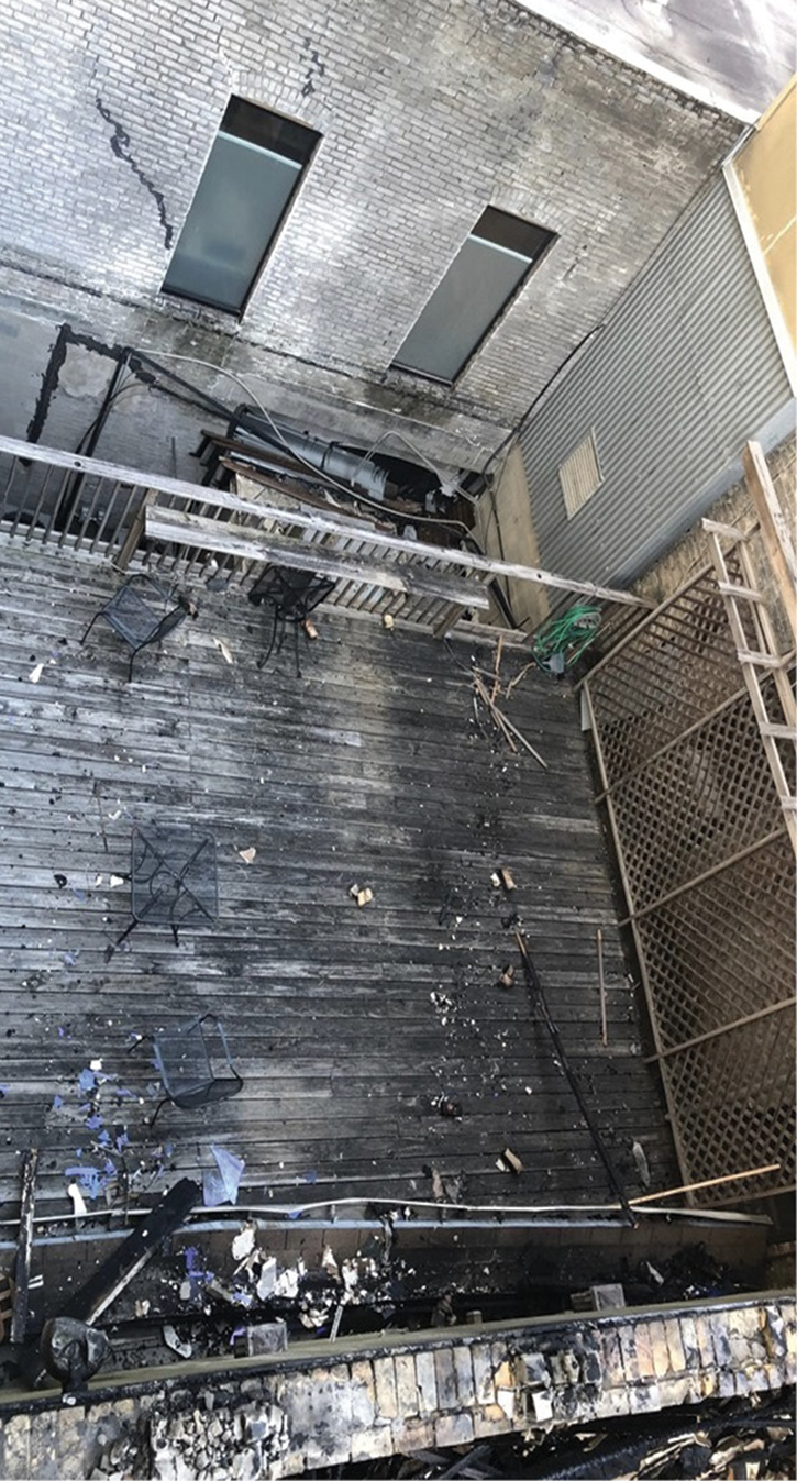 The deck on the C side where Truck 1 had a safe refuge. A closer look reveals the removed portion of the railing the crew had to climb to a storage room roof attached to the C exposure. This storage room roof is the surface from which Truck 9 lowered a 24-foot ladder to allow Truck 1 to climb to safety. 