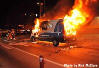 Firefighters at work as an ambulance burns