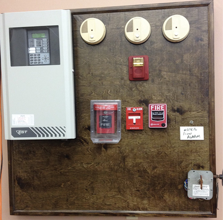 We built a fully functioning alarm system training unit complete with a working panel, four smoke detectors, three pull stations, a water flow alarm, and a working valve alarm. It was cheap, and the only thing we had to buy was the wood mount. A local alarm company did the wiring and testing for us.