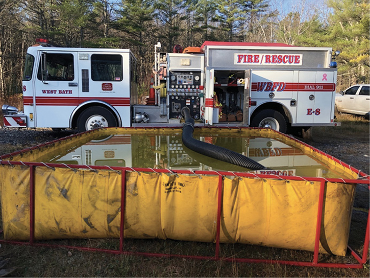 An engine company practicing rural water-supply operations using portable tanks.