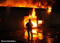 Firefighter silhouetted by flames in the burning building