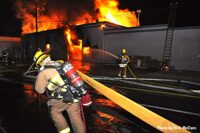 LAFD firefighter pulls a hoseline at the scene of the fire