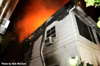 Looking up at flames atop the home