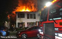 LAFD crews at fire scene with flames shooting through roof