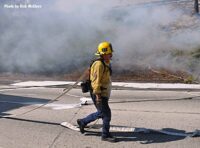 Firefighter walking along the roadway in brush fire smoke