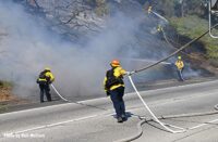 Firefighters move hoselines at California brush fire