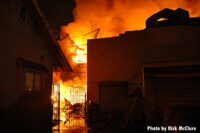 Flames roaring behind a structure in East L.A.