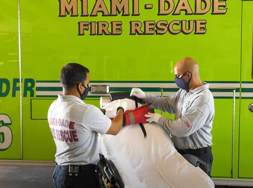 Miam-Dade fire medics work on stretcher in front of ambulance