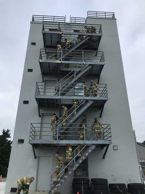 Members of Recruit Class 27 undertake a tower climb in full PPE.