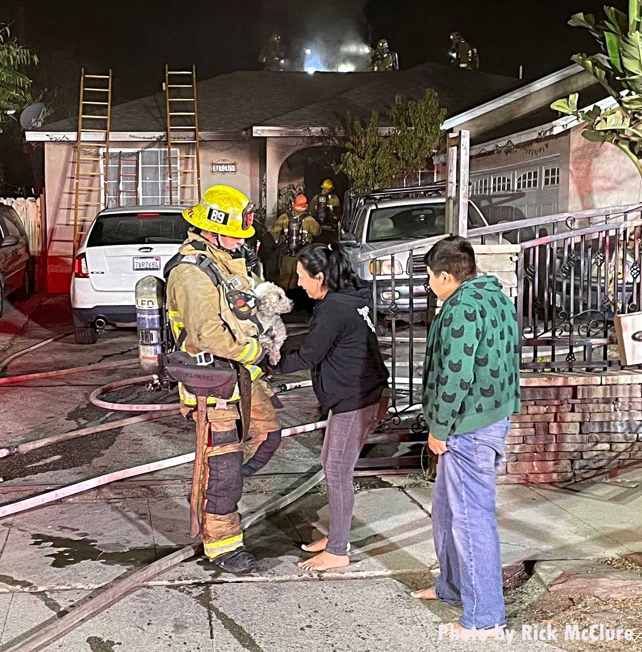 Firefighter presents the rescued dog to the family