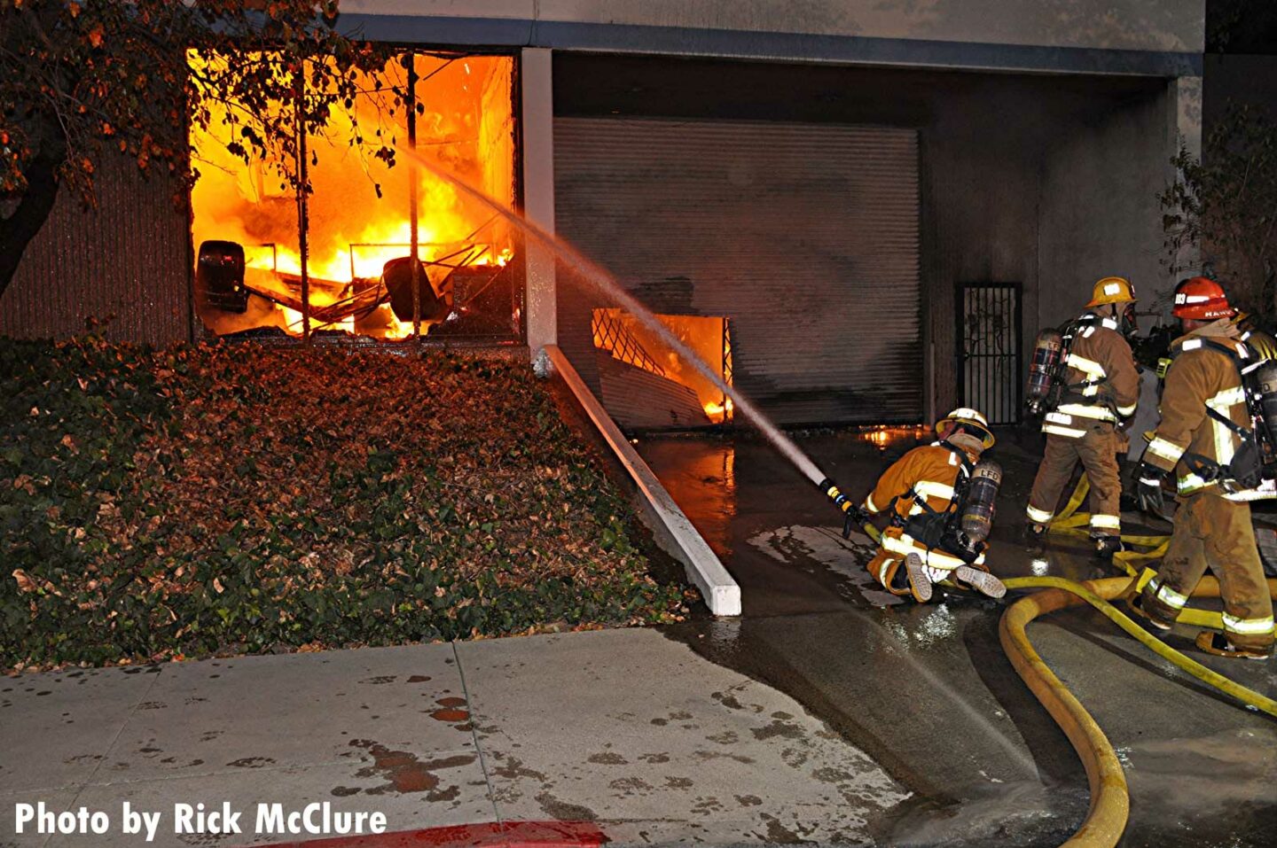 Firefighters train hoselines into the commercial structure