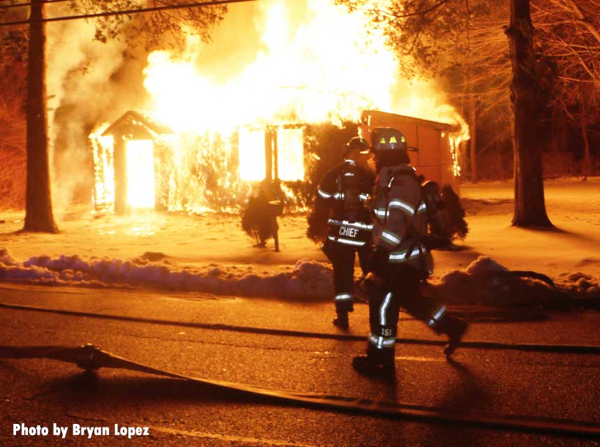 Firefighters race toward a fully engulfed home