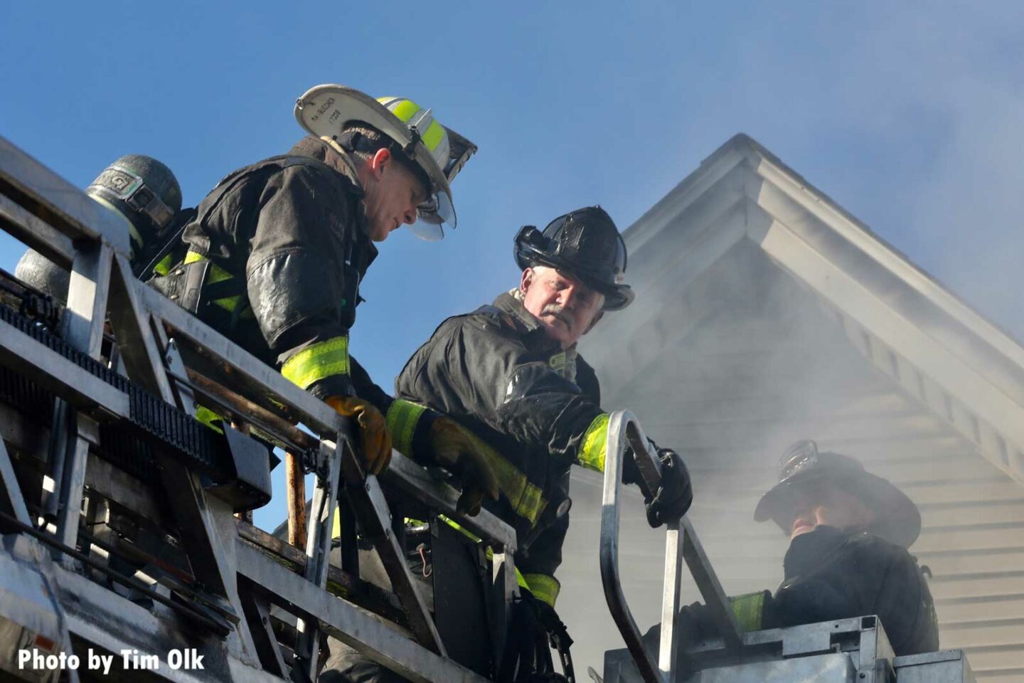 Chicago fire officer and firefighters on aerial at fire scene