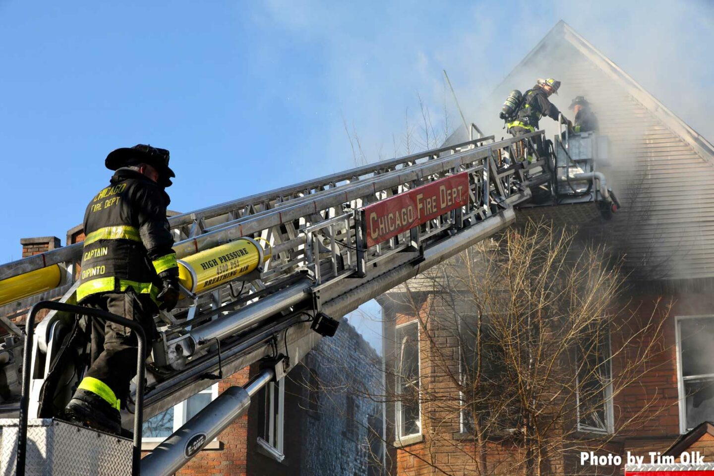 Chicago Fire Department tower ladder with members operating at house fire