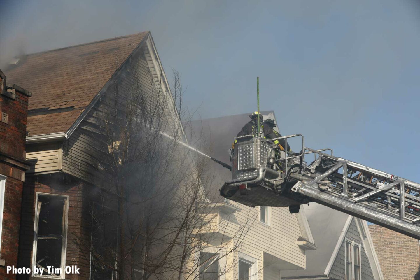 Chicago firefighters flow water from the tower ladder into a home