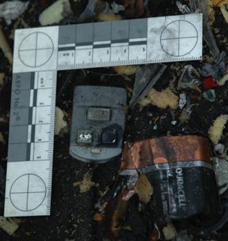 Evidence recovery from an explosion during a training exercise. The power source and the detonation device were found in the debris.