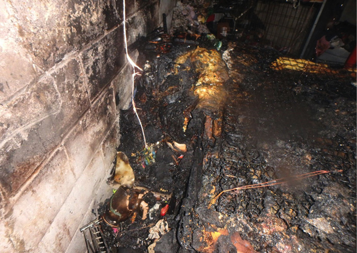 A large U-shaped fire pattern. The lines of demarcation angle down to the point of origin and show the heavy soot in the black, charred area of the block. The clean area underneath shows that the soot from the fire did not bank down to the floor. The fire was extinguished before the smoke made it all the way to the floor. The origin in this fire was on the bed, which is evidenced by the heavy mass loss.