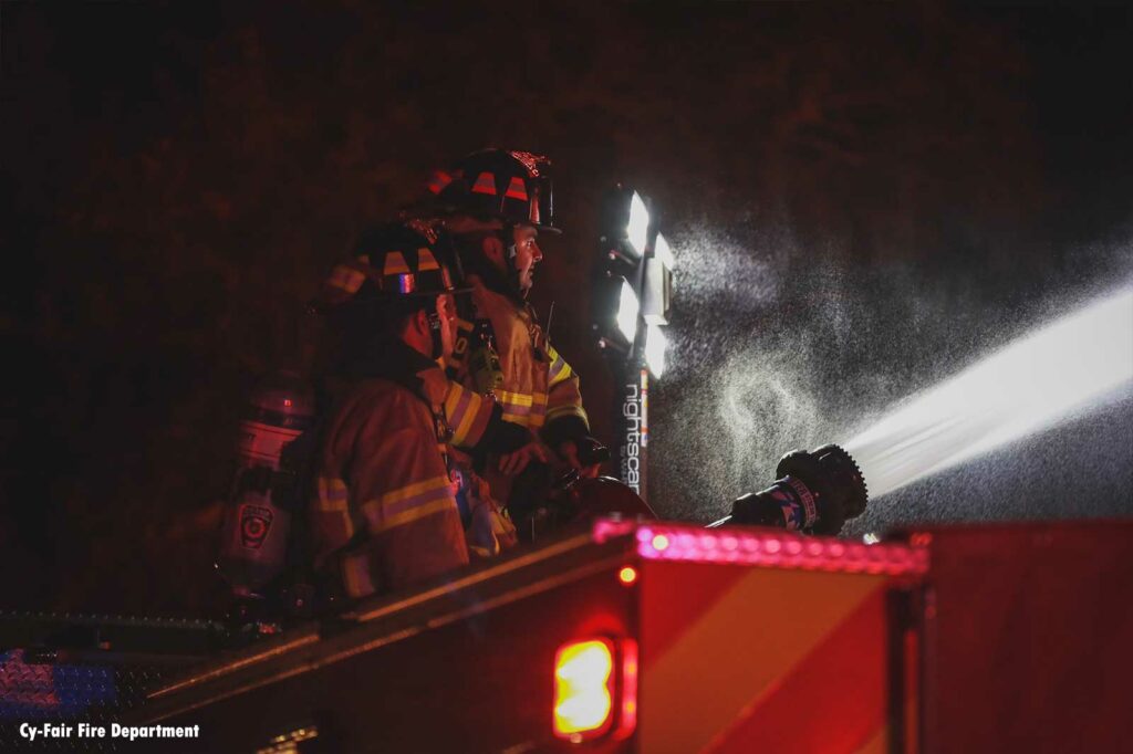 Firefighters use a master stream from an apparatus