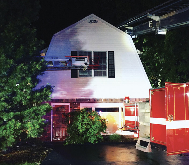 The tower ladder was backed into position so the crew could work out of the bucket and perform operations on this gambrel-shaped roof.