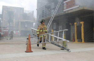 Firefighter carrying multiple ground ladders