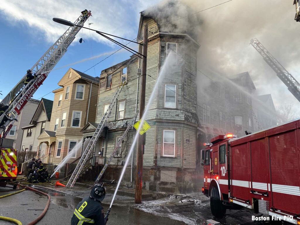 Firefighters apply two ground streams on the fire building