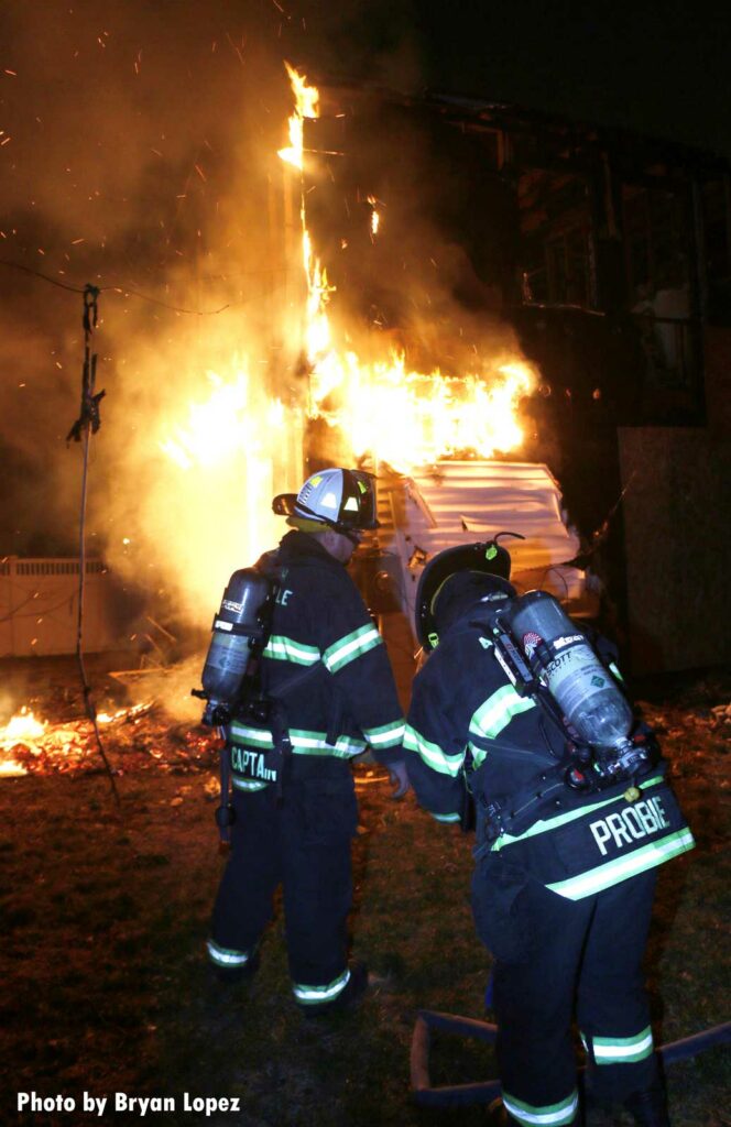 Members prepare to put water on fire at Long Island house fire