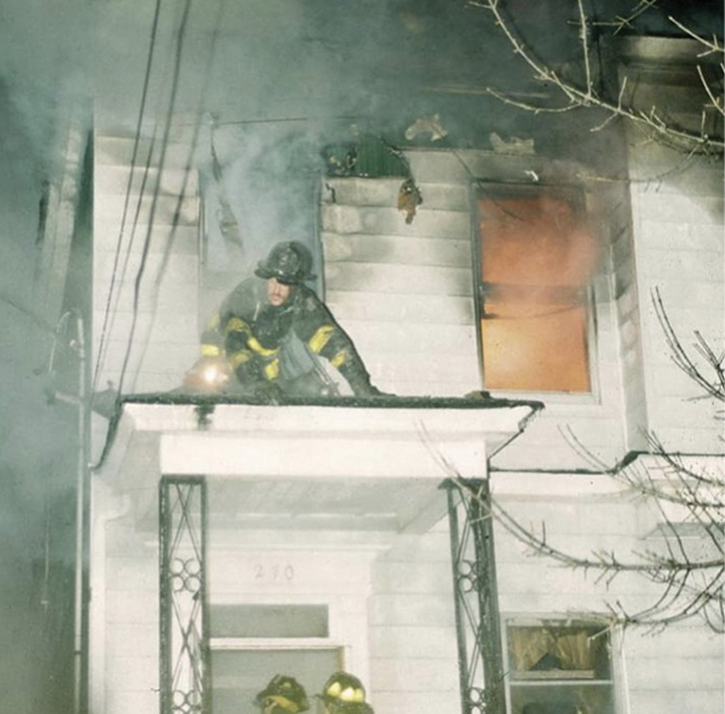  A rescue firefighter moves out onto the porch roof as conditions begin to deteriorate. topside.