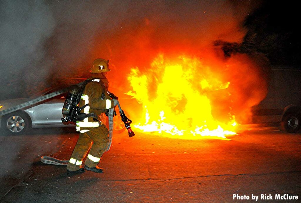 LAFD firefighter pulls a hoseline to deal with a vehicle fire