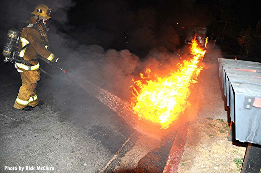 Firefighter puts water on burning fuel