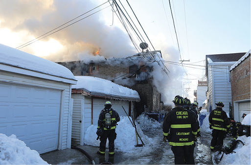  A view of the structure from the C/D side alley. Fire is still blowing through the roof.