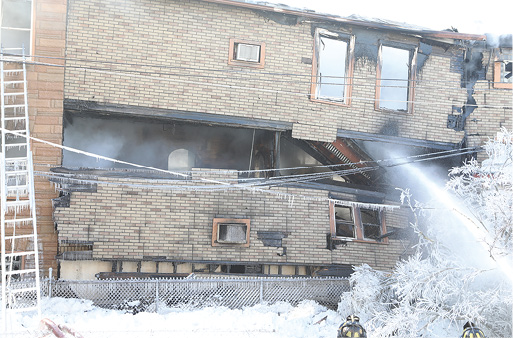 A view from the B side of the structure shows the building’s overall instability while the fire continues to burn.